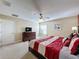 Spacious bedroom featuring neutral walls, a ceiling fan, and a wooden dresser with television at 802 Suffolk Pl, Davenport, FL 33896