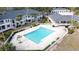 Aerial view of a bright blue community pool surrounded by lounge chairs and palm trees at 802 Suffolk Pl, Davenport, FL 33896