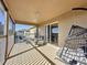 Screened-in porch with wooden floors, stylish furniture, and a relaxing hanging chair at 802 Suffolk Pl, Davenport, FL 33896