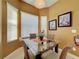 Cozy dining area with a glass table set and natural light from three windows at 802 Suffolk Pl, Davenport, FL 33896