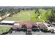Aerial shot of the clubhouse and golf course featuring manicured lawns, mature trees and practice range at 802 Suffolk Pl, Davenport, FL 33896