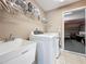 Laundry room features a sink, washer and dryer, access to garage game room, and tile flooring at 802 Suffolk Pl, Davenport, FL 33896