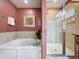 Detailed view of the main bathroom with a soaking tub and shower, complemented by stylish fixtures and finishes at 802 Suffolk Pl, Davenport, FL 33896