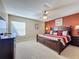 Comfortable main bedroom with ceiling fan, carpet, and large bed and furnishings at 802 Suffolk Pl, Davenport, FL 33896