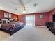 Well-lit main bedroom featuring plush carpet, ceiling fan, access to a private balcony, and stylish furnishings at 802 Suffolk Pl, Davenport, FL 33896