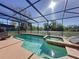 Screened-in pool and spa with clear blue water, surrounded by a spacious deck area at 802 Suffolk Pl, Davenport, FL 33896