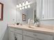 Bathroom featuring a large mirror, a well-lit vanity, and neutral decor at 8517 Crystal Cove Loop, Kissimmee, FL 34747