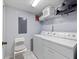 Functional laundry room equipped with a washer, dryer, shelving, and storage space at 8517 Crystal Cove Loop, Kissimmee, FL 34747