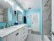 Bathroom boasts blue walls, white vanity with double sinks, and black and white tiled floors at 876 Lobster Ct, Kissimmee, FL 34744