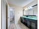 Bathroom featuring double vanity with black cabinets and access to shower stall at 876 Lobster Ct, Kissimmee, FL 34744