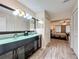 Bathroom featuring double vanity with black cabinets, hall access, and bedroom at 876 Lobster Ct, Kissimmee, FL 34744