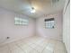 A bright bedroom is freshly painted with tile floors, two windows and closet space at 876 Lobster Ct, Kissimmee, FL 34744