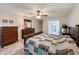 Bedroom includes wood laminate flooring, a ceiling fan, a dresser, and an entry hallway at 876 Lobster Ct, Kissimmee, FL 34744