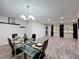 Open dining room with glass table, chandelier, and wood-look flooring at 876 Lobster Ct, Kissimmee, FL 34744