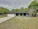 Charming single-story home featuring an attached garage, a well-maintained lawn, and freshly painted exterior at 876 Lobster Ct, Kissimmee, FL 34744