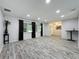 Bright and airy living room with dark curtains and wood-look laminate flooring at 876 Lobster Ct, Kissimmee, FL 34744