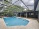 The in-ground pool has a screen enclosure and concrete decking, with an outdoor seating area nearby at 876 Lobster Ct, Kissimmee, FL 34744