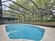 Pool with blue water, screen enclosure, concrete decking, and a pool cleaner in the water at 876 Lobster Ct, Kissimmee, FL 34744