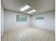 Room with neutral walls, tile flooring, two windows, and fluorescent lighting at 876 Lobster Ct, Kissimmee, FL 34744
