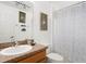 Clean bathroom with a granite countertop, neutral-toned walls, and a leaf-patterned shower curtain at 917 Orange Cosmos Blvd, Davenport, FL 33837