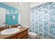 Bright bathroom featuring turquoise walls, a neutral countertop, and turtle-themed shower curtain at 917 Orange Cosmos Blvd, Davenport, FL 33837