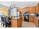 Beautiful kitchen with wooden cabinets, granite countertops, stainless steel appliances, and an island with barstool seating at 917 Orange Cosmos Blvd, Davenport, FL 33837