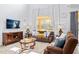Comfortable living room with a brown sofa, a patterned rug, and a large window at 917 Orange Cosmos Blvd, Davenport, FL 33837