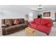 Inviting living room showcasing a brown couch, red couch, and stylish decor at 917 Orange Cosmos Blvd, Davenport, FL 33837