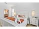 Bright bedroom featuring a white bed with an orange throw, two nightstands, and a window at 917 Orange Cosmos Blvd, Davenport, FL 33837