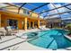 Sparkling screened-in pool with a jacuzzi, poolside lounge area, and sunny skies at 917 Orange Cosmos Blvd, Davenport, FL 33837