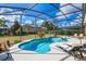Relaxing pool and patio area surrounded by screened enclosure, lounge chairs, and tropical landscaping at 917 Orange Cosmos Blvd, Davenport, FL 33837