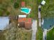 Aerial view of a backyard featuring a pool, cabana, long driveway, and a lush green lawn at 9916 Jackson Rd, Leesburg, FL 34788