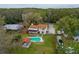 A backyard with a screened porch, pool, cabana, mature trees, and a long driveway leading to the street at 9916 Jackson Rd, Leesburg, FL 34788