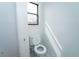 Cozy water closet featuring a low-flow toilet, white walls, and natural light at 9916 Jackson Rd, Leesburg, FL 34788