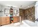 Bathroom with double sinks and unique stone-detailed shower/tub at 9916 Jackson Rd, Leesburg, FL 34788