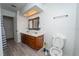 Bathroom featuring double sinks, wood cabinets, skylight, and tile flooring at 9916 Jackson Rd, Leesburg, FL 34788