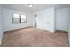 Bedroom with neutral carpeting, a window, and access to a bathroom and closet at 9916 Jackson Rd, Leesburg, FL 34788