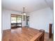 Bright dining area featuring wood floors, a classic chandelier, and sliding glass doors at 9916 Jackson Rd, Leesburg, FL 34788