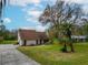 Spacious home featuring a long driveway, mature trees, and a lush green lawn at 9916 Jackson Rd, Leesburg, FL 34788