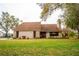 Charming single-story home featuring a brick chimney, a well-manicured lawn, and a inviting front entrance at 9916 Jackson Rd, Leesburg, FL 34788