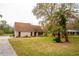 Charming home featuring mature palm trees, landscaping, a well-maintained lawn, and inviting curb appeal at 9916 Jackson Rd, Leesburg, FL 34788