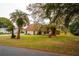 Charming home with a spacious front yard featuring mature trees, plants, and landscaping at 9916 Jackson Rd, Leesburg, FL 34788