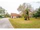 Charming home with a large front yard, mature trees, a well-maintained lawn, and inviting curb appeal at 9916 Jackson Rd, Leesburg, FL 34788