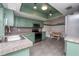 Eat-in kitchen featuring green cabinets, stainless steel appliances, and granite countertops at 9916 Jackson Rd, Leesburg, FL 34788