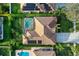 An overhead shot of the home and roof showing the screened in pool, greenery, and solar panels at 10986 Ledgement Ln, Windermere, FL 34786