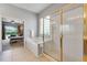 Bright bathroom features bathtub and shower with glass door with gold trim and bedroom view at 10986 Ledgement Ln, Windermere, FL 34786