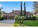 Beautiful home featuring a large garage, lush landscaping, and a well-maintained lawn at 10986 Ledgement Ln, Windermere, FL 34786