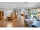Open-concept living room with hardwood floors, dining table, modern furniture, and large windows at 10986 Ledgement Ln, Windermere, FL 34786