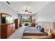 Bright main bedroom featuring a king-size bed and view of the outdoor pool at 10986 Ledgement Ln, Windermere, FL 34786