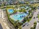 Aerial view of a community pool with multiple swimming areas, lounge chairs, and palm trees at 13831 Briand Ave, Orlando, FL 32827